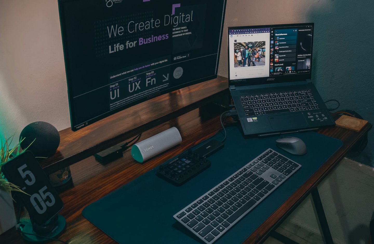 Laptop i monitor wyświetlające treści cyfrowe na drewnianym biurku.