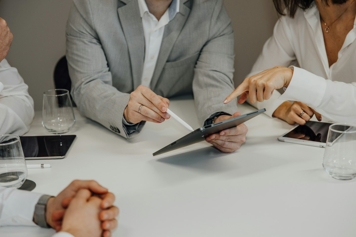 Profesjonaliści biznesowi współpracujący przy tablecie przy białym stole.